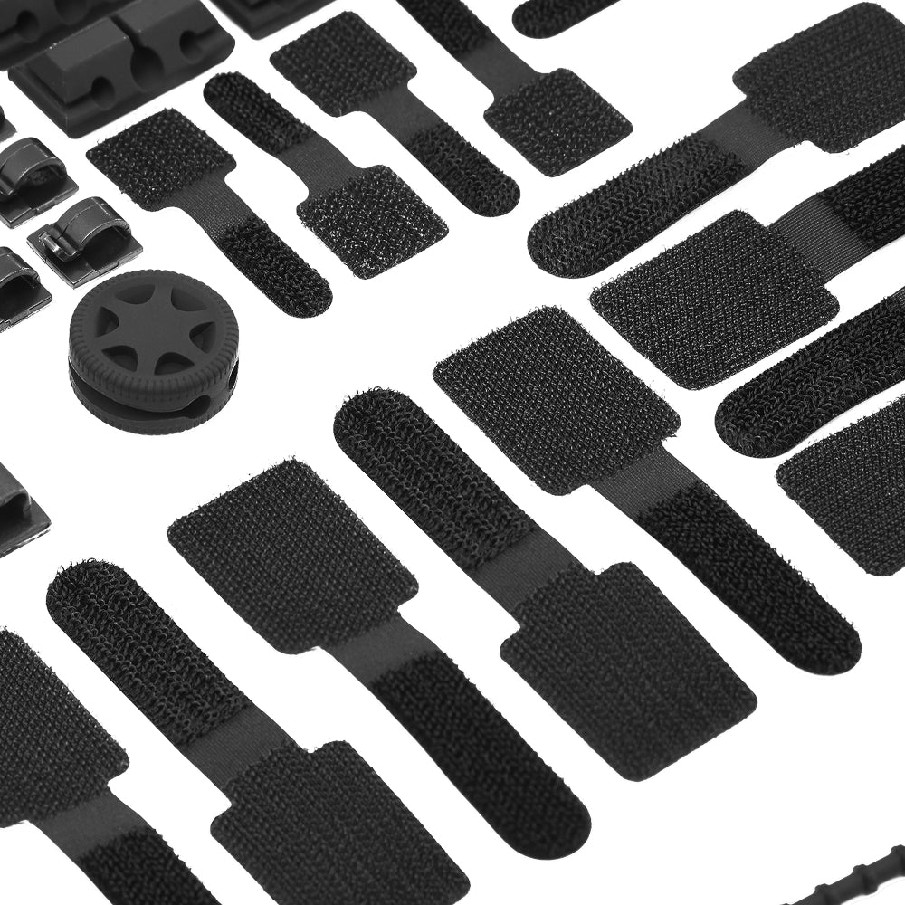 The Cable Management Kit includes black hook-and-loop cable straps, plastic clips, and a ventilated round black component, all neatly arranged on a white background—ideal for organizing your cables.