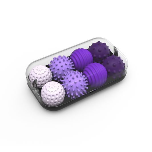 The Signets set features a transparent rectangular container holding eight lavender textured balls, each with unique spiked or dimpled surfaces for fidgeting, all neatly arranged inside the box.