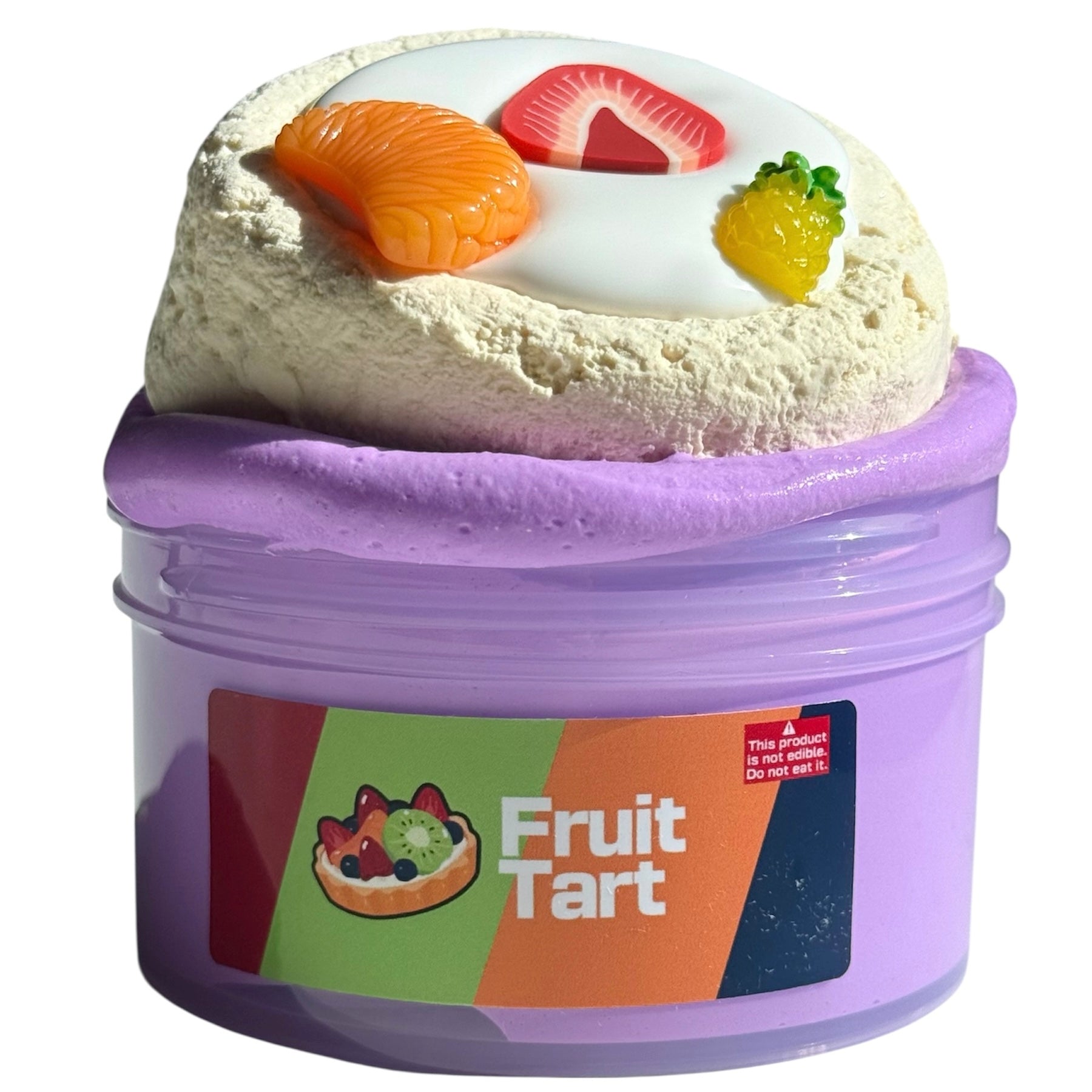 A purple cup labeled Fruit Tart DIY Clay Slime contains 7 oz of fruit smoothie-scented purple slime with a white center, a tart decoration, and three random fruit charms. Warning: This is not food. Do not eat it.