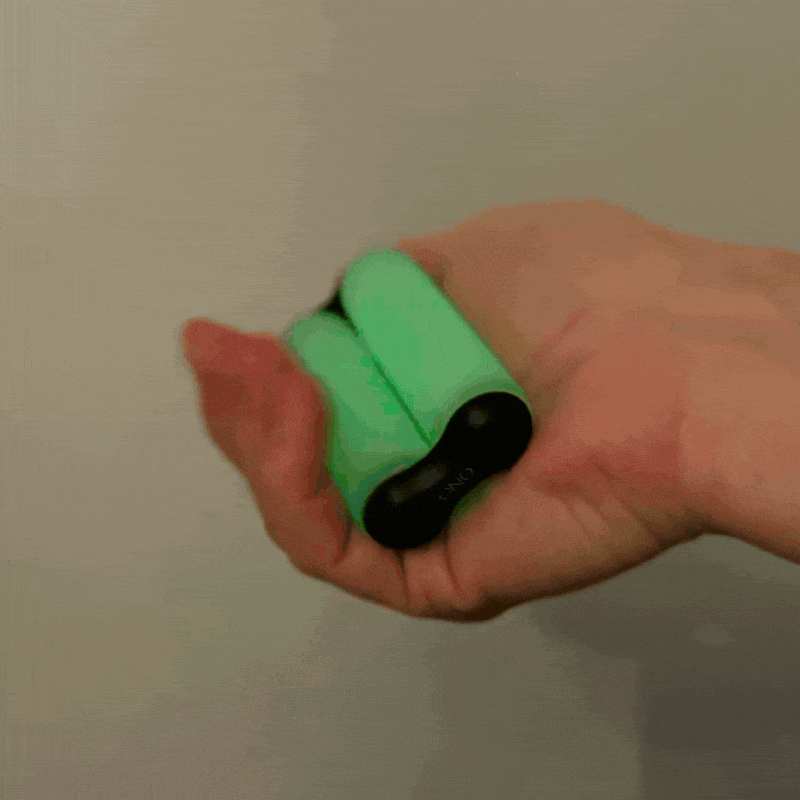 A hand squeezes two ONO Roller Soft Touch Plastic toys, making their black ends pop out and retract with a squishy, spring-like motion—great for stress relief.