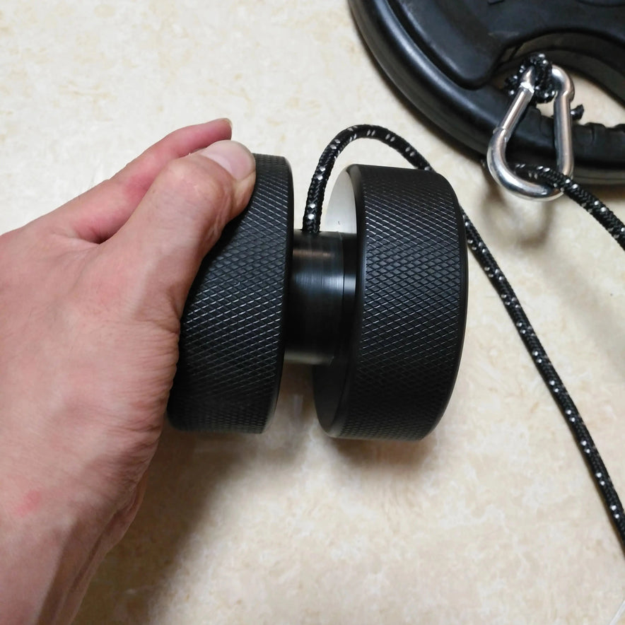 A hand features the Finger Grip and Forearm Strength Trainer, a black rubber exercise wheel with a sturdy rope, anti-slip grip, and metal hook. The light background emphasizes its sleek design and functionality.