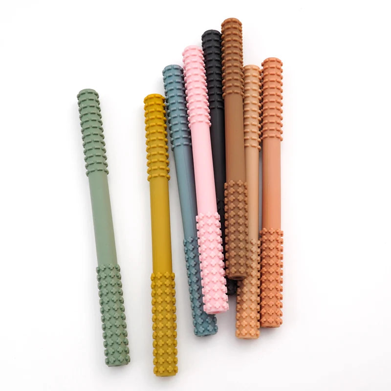 The Essential Tiny Teething Toy for Infants, made of textured silicone for oral protection, comes in pastel green, yellow, pink, and brown. These straws are arranged semi-circularly on a white background to highlight their appeal for baby health through safe chewing and fidget fun.