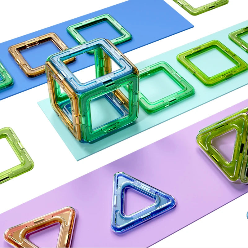 The Giant Magnetic Building Blocks Set for Kids features colorful geometric shapes like squares and triangles in green, blue, and transparent shades. Arranged on overlapping pastel surfaces, they form a cube using safe, durable material—ideal for STEM learning for ages 4-12.
