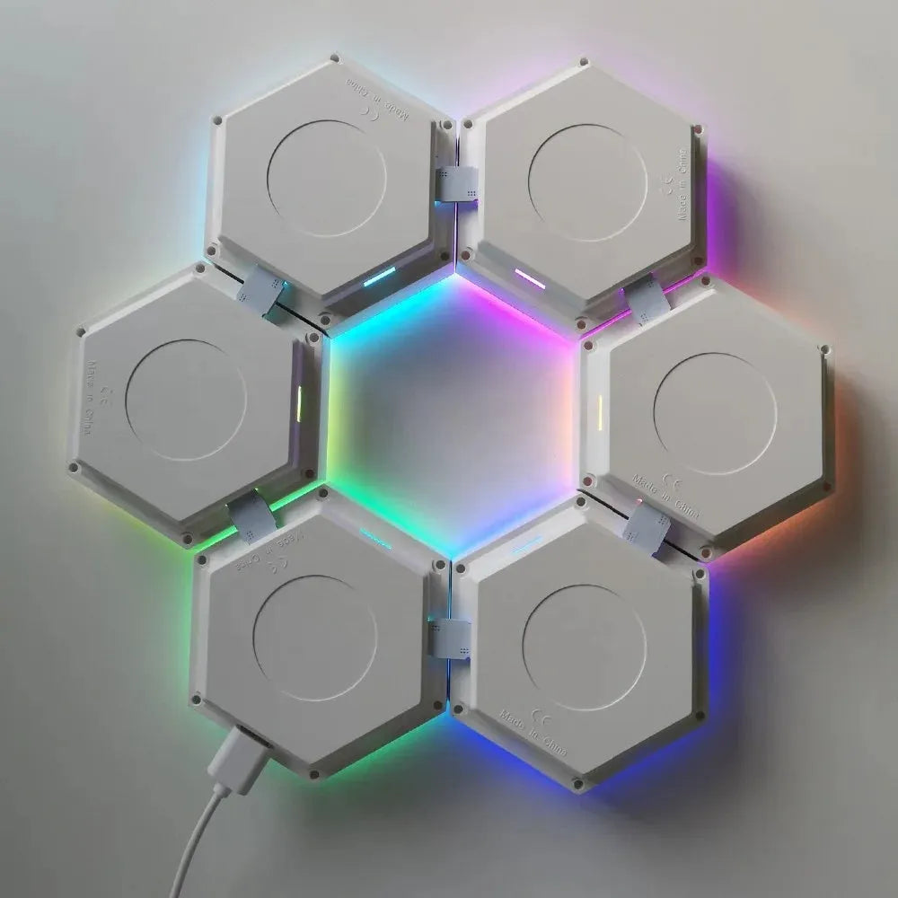 Six Hexagonal LED Modular Night Light Panels for Sensory Rooms are joined edge-to-edge in a circular pattern, glowing softly with color-changing lights. One panel connects to a power cable, creating a calming, versatile night light for autism support.