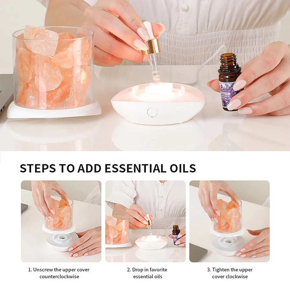 A person uses a dropper to add essential oil to the Crystal Salt Lamp with USB Aroma Purifier & LED Multicolor Night Light, surrounded by pink salt-like crystals. Below are three instructional images: unscrew cover, add essential oil, tighten cover.