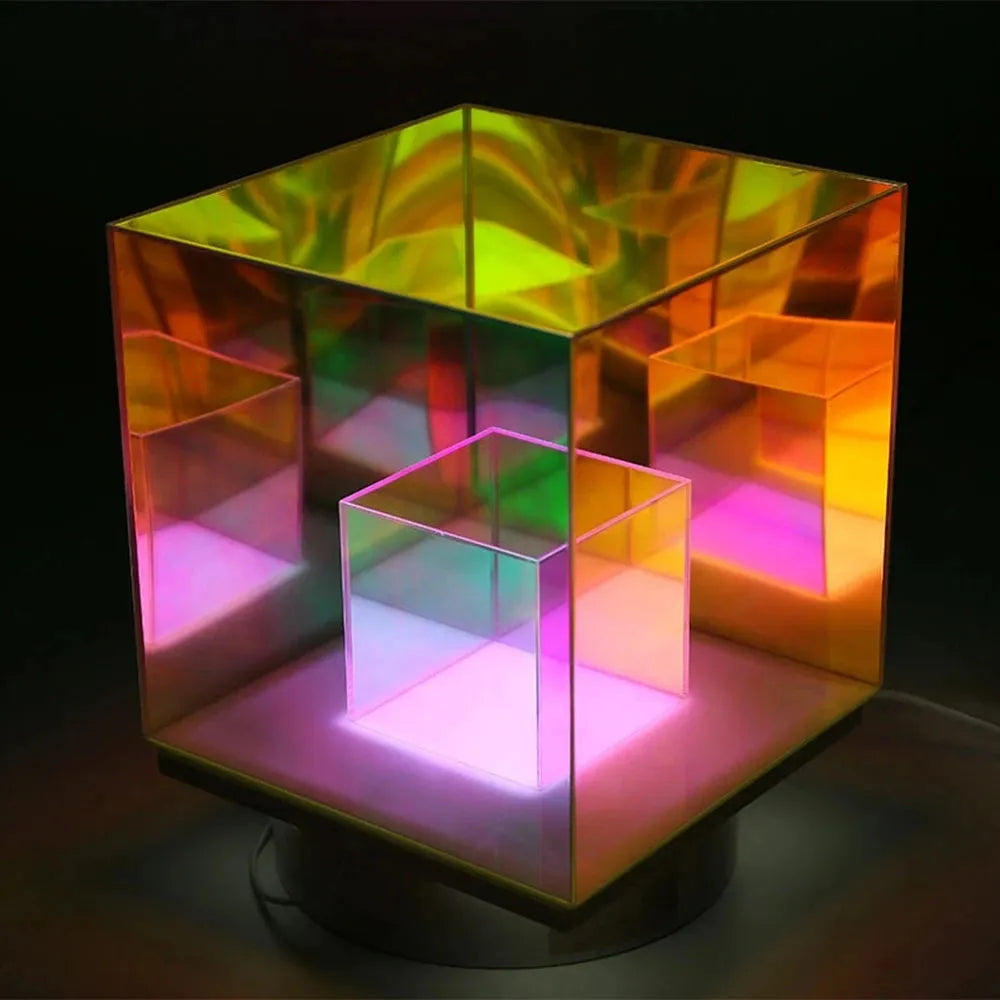 The Vibrant RGB LED Night Light for Parties and Home Décor showcases a geometric optical illusion with a larger iridescent cube around a smaller translucent one. Dynamic RGB lighting offers vibrant colors—yellow, green, pink—with a reflective, mirror-like effect.