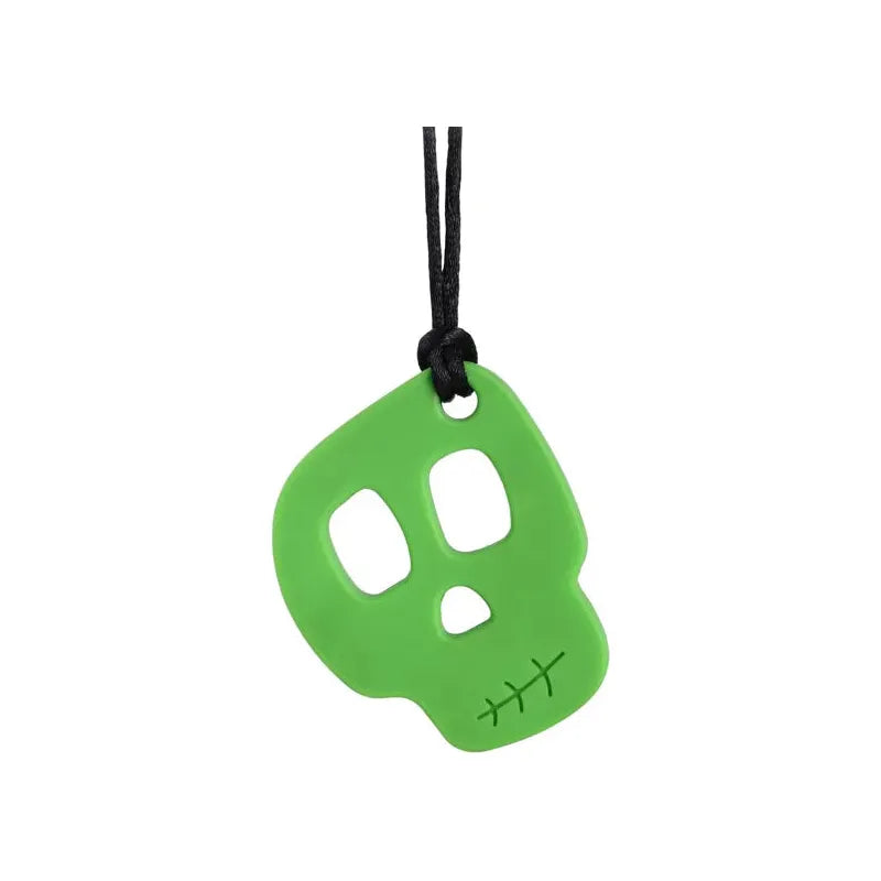 The Silicone Skull Teething Necklace for Babies features a green, skull-shaped silicone pendant with hollow eyes and a stitched mouth design. Its smooth surface hangs from a black cord, making it an ideal chewy toy for teething relief as well as sensory support for autism and ADHD.
