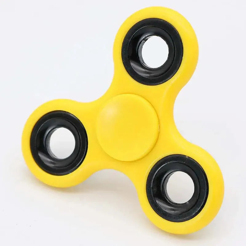 A yellow Premium ABS Tri-Spinner Fidget Toy for Stress Relief, ideal for all ages, including individuals with autism and ADHD, rests on a neutral background. It has three rounded arms with black circular bearings.