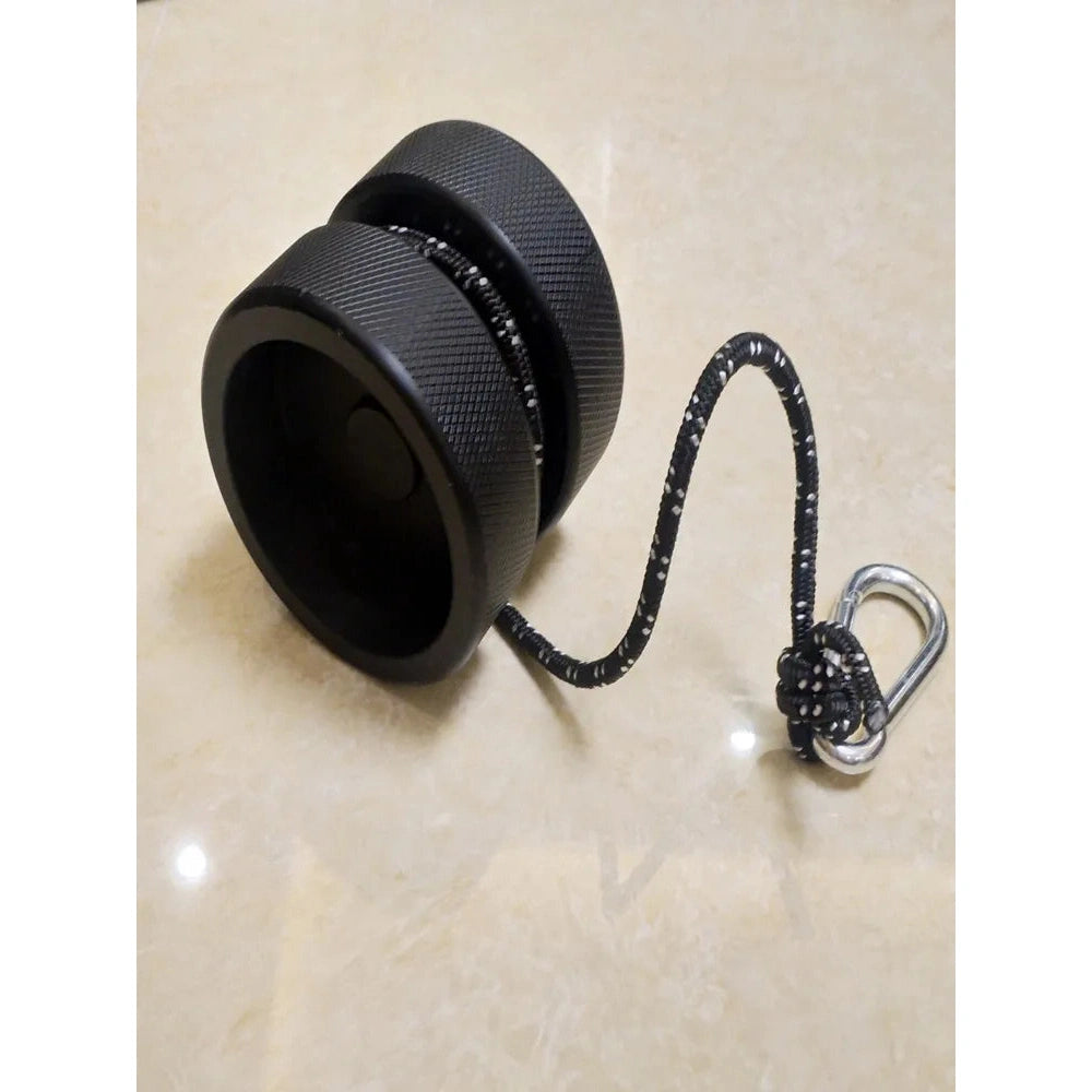 The Finger Grip and Forearm Strength Trainer is a black, cylindrical tool with a textured surface, designed for forearm strength training. It has a thick rope loop connected to a silver carabiner and rests on a smooth, light-colored surface.