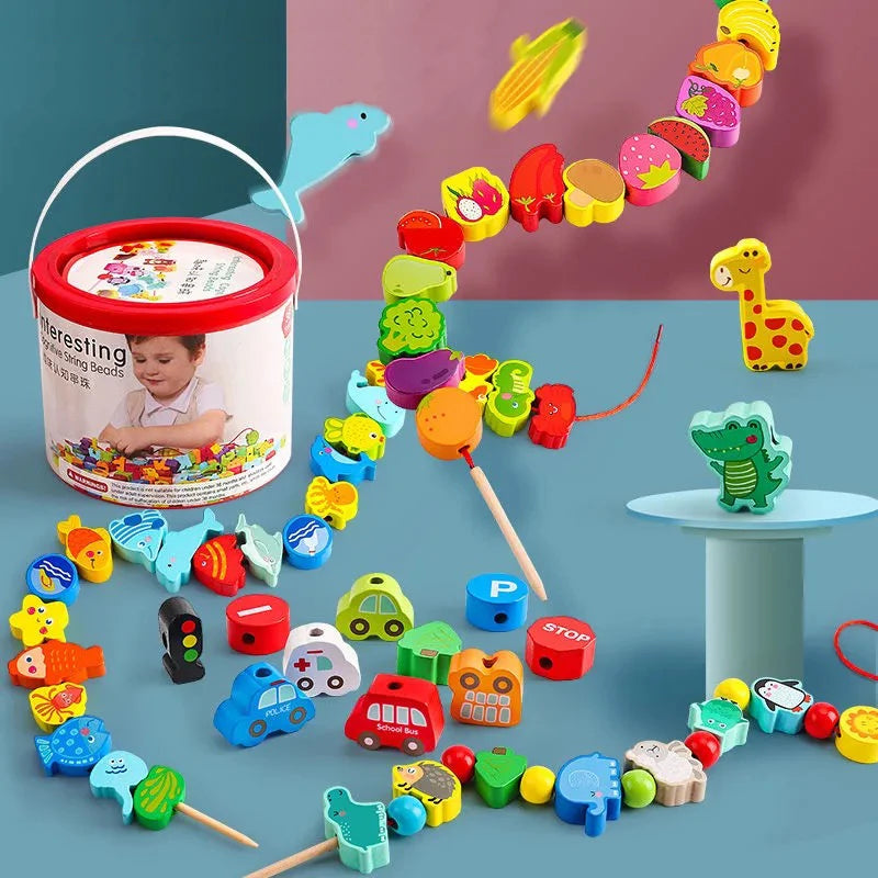 A blue surface displays an array of Wooden Beaded Toys with fruits, animals, and vehicles. Safe materials crafted some with a red string threading them together. In the background, a cylindrical container emphasizes their educational purpose for childrens early education.