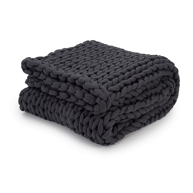 A chunky, hand-knit Knit Weighted Blanket in charcoal, featuring a braided design and thick yarn, is folded neatly on a white background.