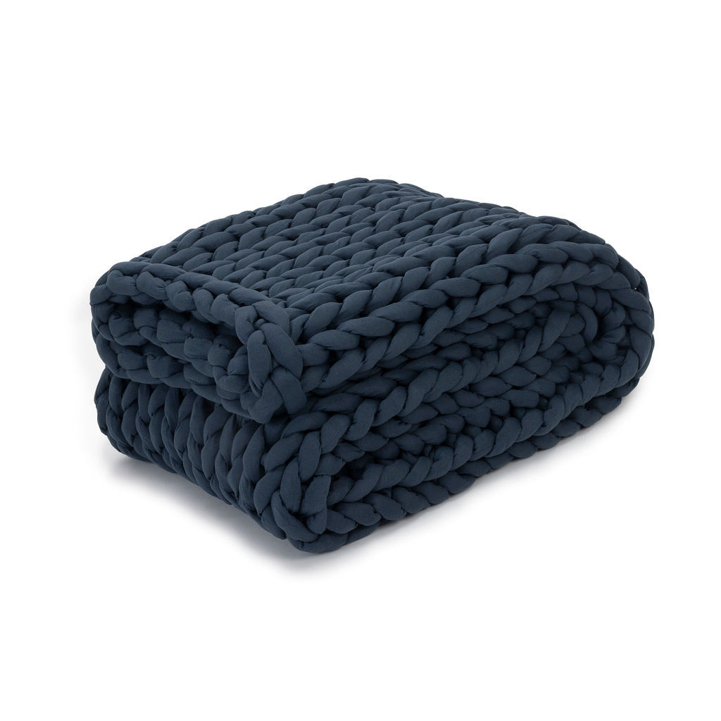 A Knit Weighted Blanket in Dusty Blue is neatly folded, showcasing its thick braided texture for a cozy, plush look.