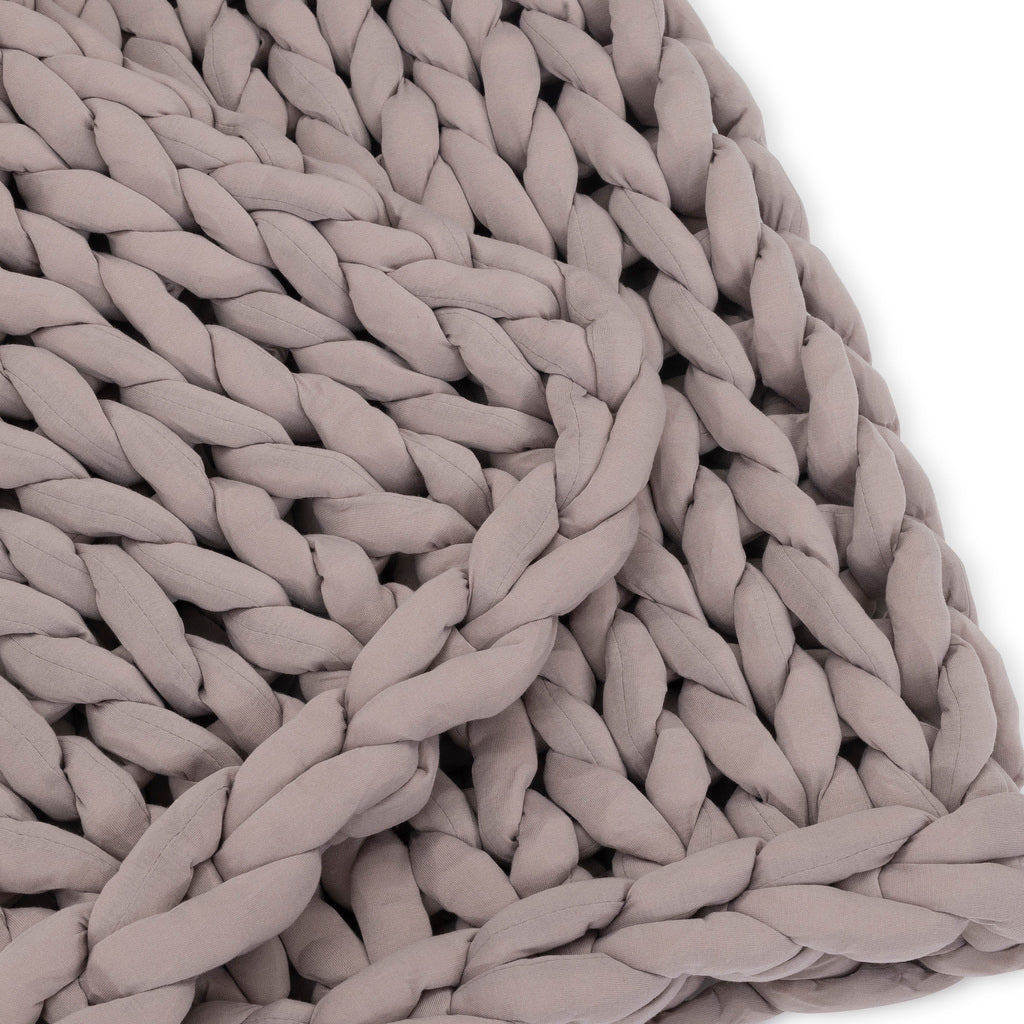 Close-up of the Knit Weighted Blanket in soft taupe, featuring chunky, braided strands that form a textured pattern with visible loops and braids, set against a white background.