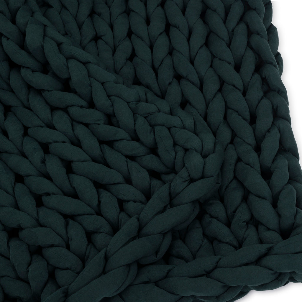Close-up of the Knit Weighted Blanket in dark green, featuring thick, braided yarn strands woven together to create a beautifully textured, chunky knit pattern.