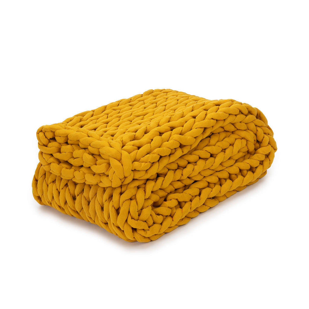 The Knit Weighted Blanket in marigold features a folded, chunky, breathable knit design and is displayed on a white background.