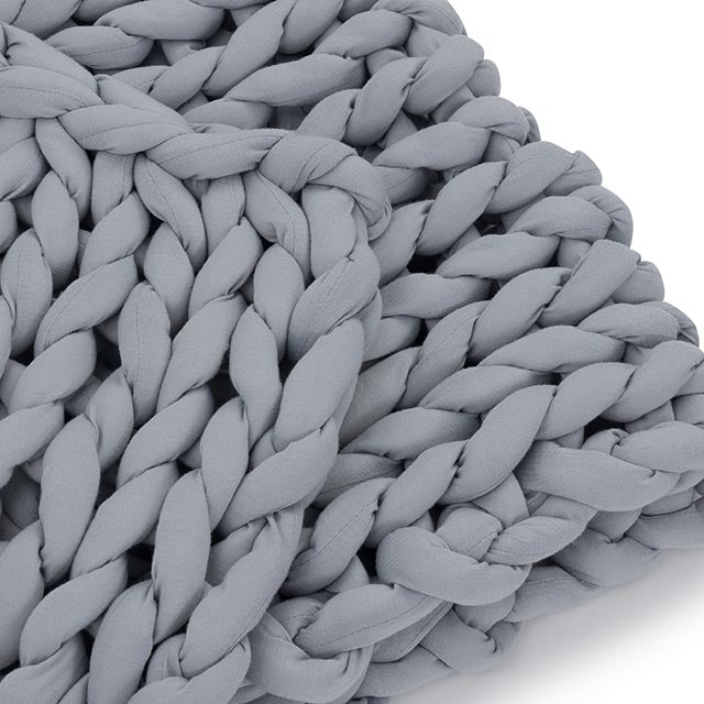 Close-up of the Knit Weighted Blanket in light gray, featuring thick, soft yarn loops and a large, textured braided pattern.