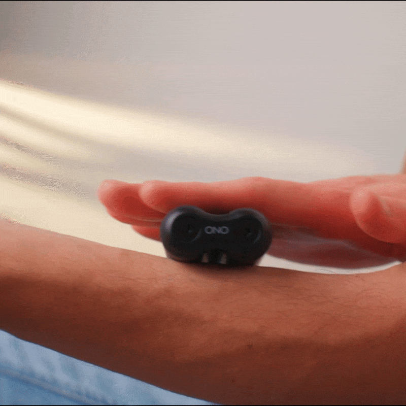 A person rolls an ONO Roller Aluminum—sleek, black, and small—between their hand and forearm to relieve stress or for sensory stimulation while fidgeting.