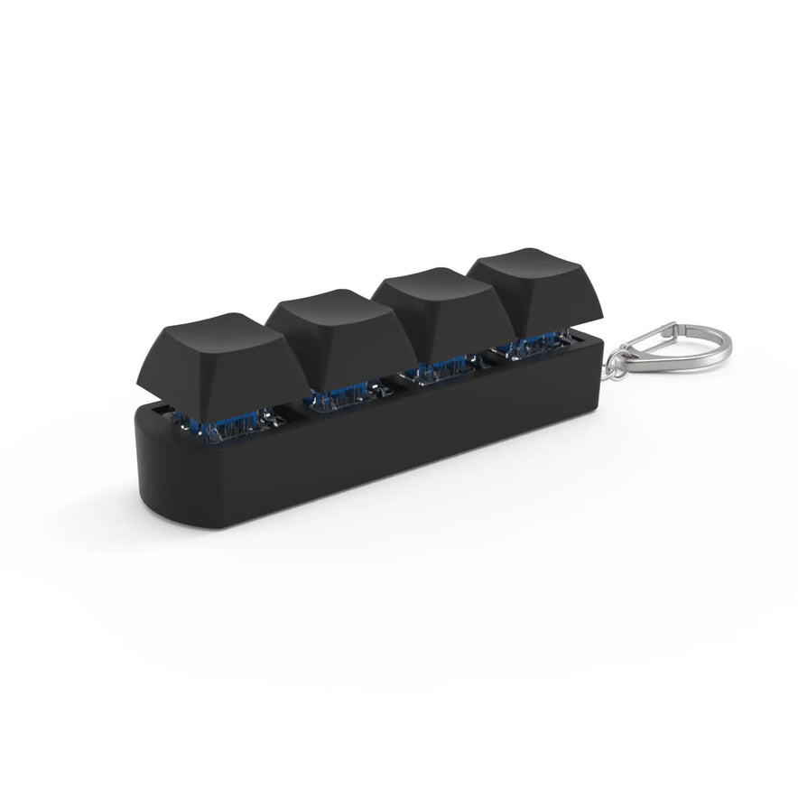 The 4Keys Finger Button Anti Stress Keychain features four black mechanical keyboard keycaps on a rectangular base with a metal keyring—ideal for office decompression and calming stress relief on the go. Suitable for kids and adults.