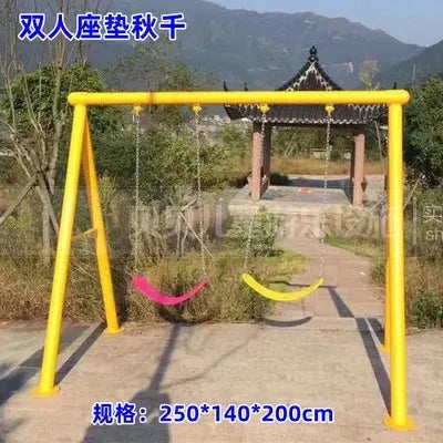 The Outdoor Steel Climbing Frame Swing for Childrens Sensory Integration Training features a yellow swing set with two colorful swings, one pink and one red, surrounded by greenery with a distant pavilion and mountains. The scene also includes Chinese text and dimensions in centimeters.