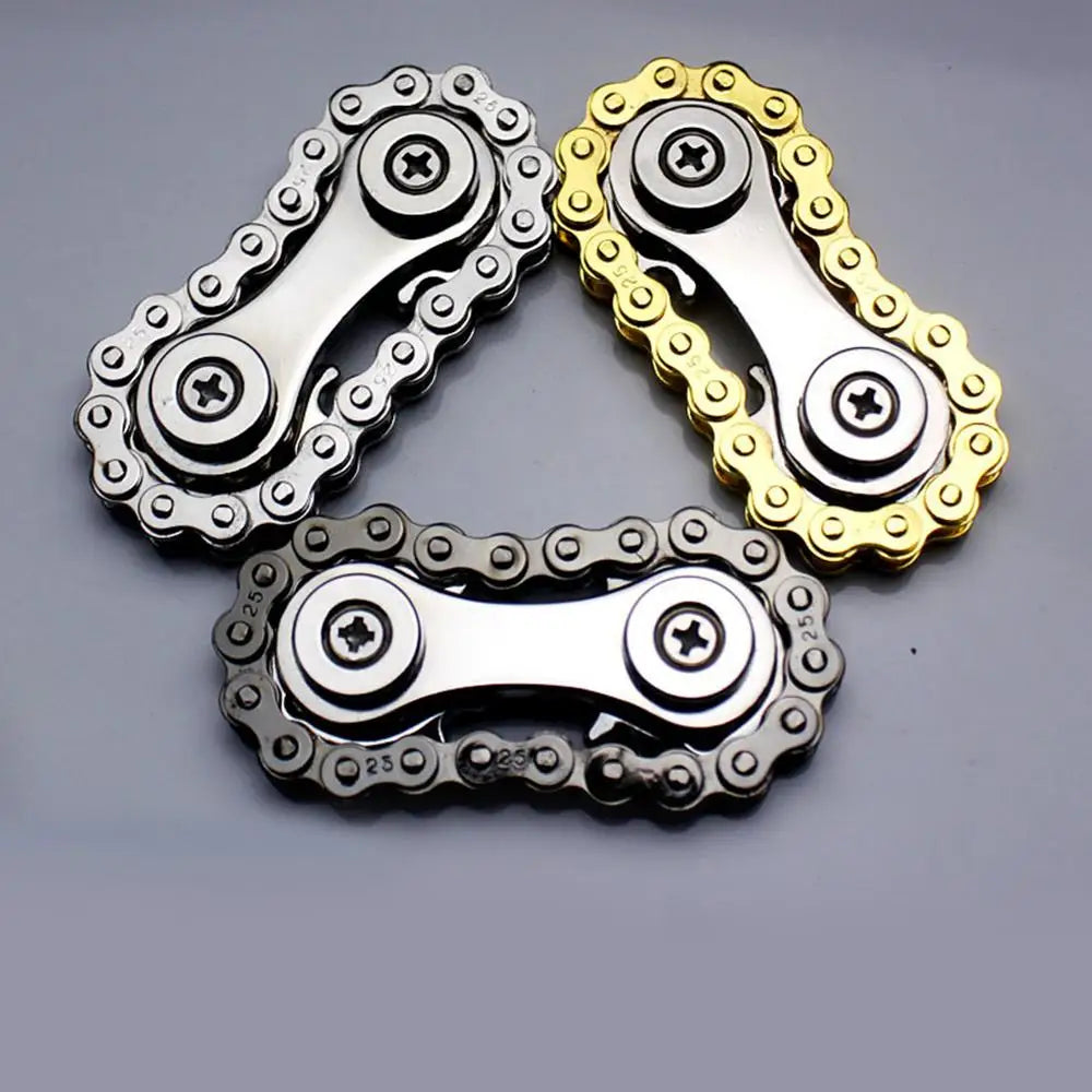 Displayed on a flat surface are three Sprockets Flywheel Fingertip Gyro spinners with chain-like designs: one silver, one gold, and one dark metallic. Each features two gears linked by a chain, ideal for dropshipping enthusiasts seeking quality and style.