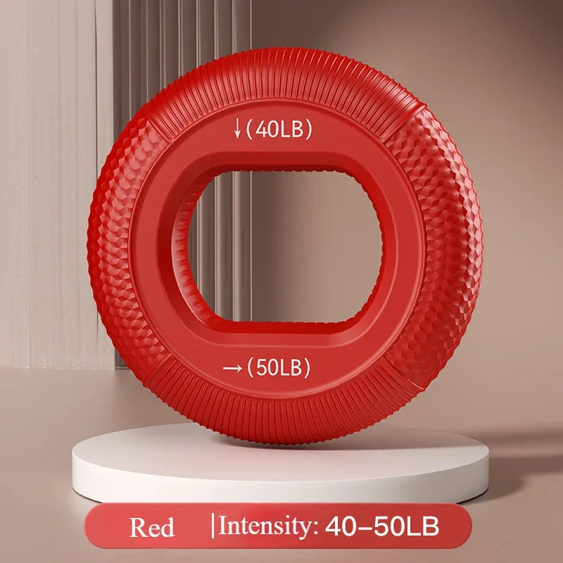 The red Silicone Grip Trainer Ring for Hand Strengthening and Wrist Rehabilitation stands upright on a white platform, marked with 40LB and 50LB to show resistance intensity. Its textured surface is perfect for enhancing grip strength against a backdrop of vertical lines and soft brown shades.