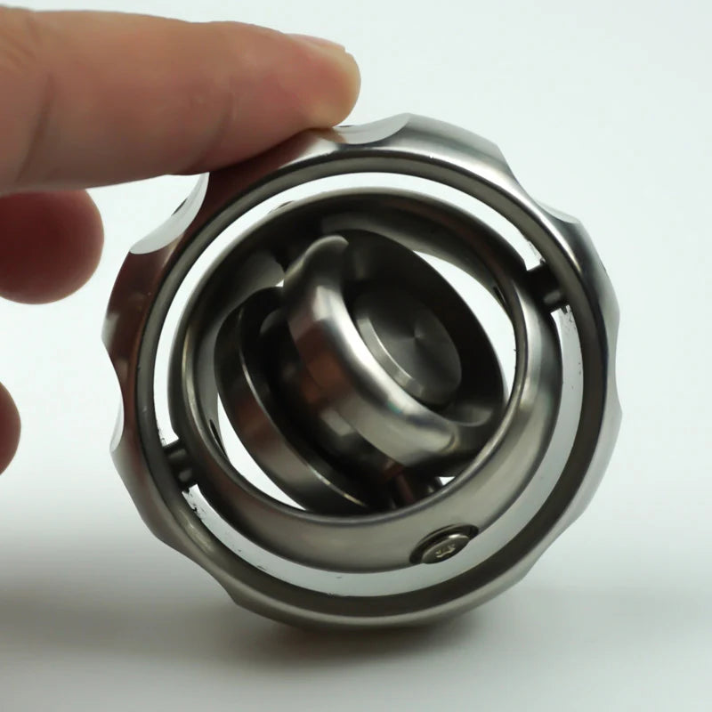 A hand gently holds the Stainless Steel Fidget EDC Gyroscope Spinner, highlighting its metallic design with layered circles. This stress relief toy features a shiny, industrial steel look with smooth and grooved edges to calm the mind and engage fingers.