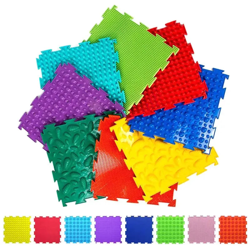 The Montessori Sensory Integration Training Balance Stones for Kids offer a fan-shaped arrangement of colorful puzzle mats in green, red, blue, yellow, purple, and turquoise. Each mat has a unique texture for tactile play with mini versions displayed in a row at the bottom.