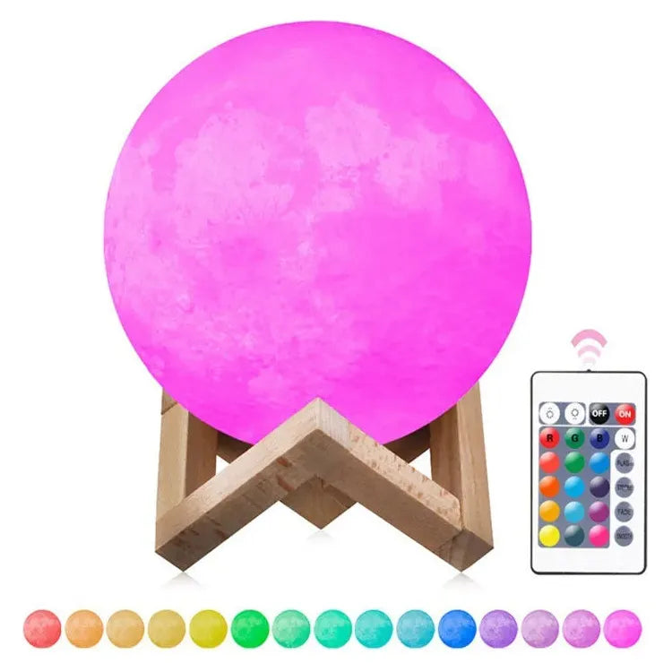The Celestial 3D Moon Lamp LED Night Light sits elegantly on a wooden stand, illuminated in pink and surrounded by vibrant spheres. A multi-button remote control invites interaction, making this enchanting starry decor perfect for creating a tranquil atmosphere in any space.