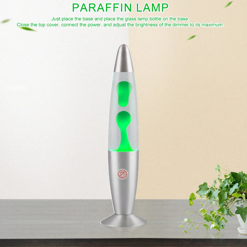 The Luminous Volcano Lava Jellyfish LED Night Light, with its green lava, sits on the table creating a relaxing ambiance. Its sleek, elongated design adds elegance to the serene setup enhanced by a potted plant. Instructions for use are displayed above.
