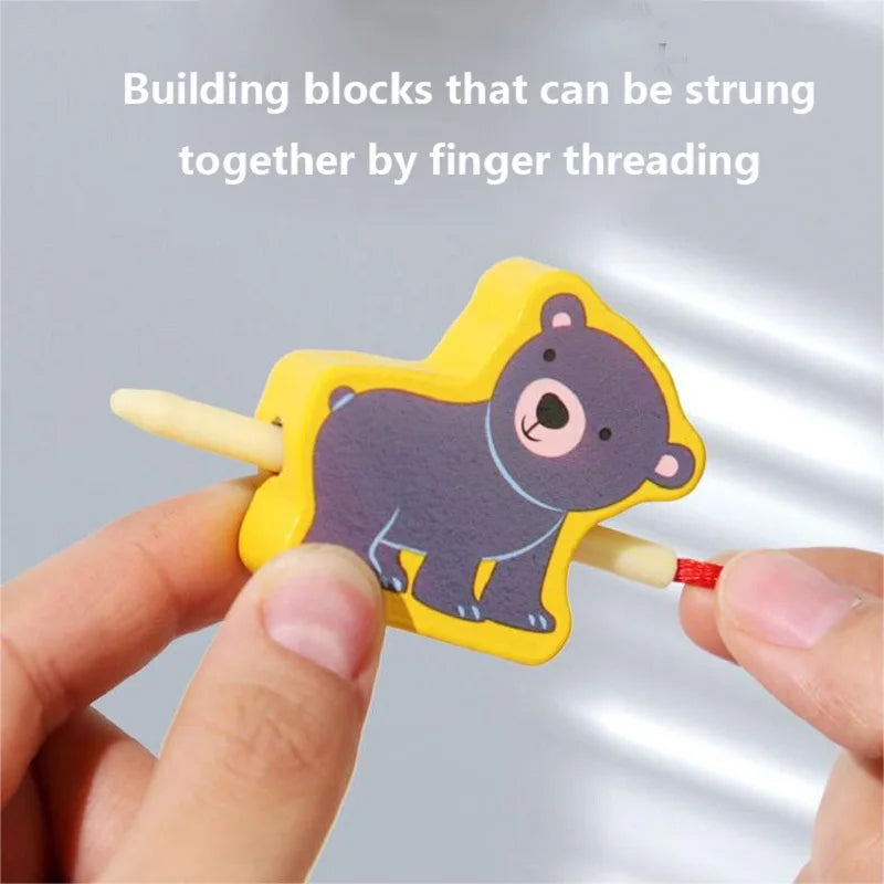 Close-up of hands threading a string through a bear-shaped block toy. White text above reads: New Children Wooden Toys Baby DIY Toy Cartoon Fruit Animal Traffic Stringing Threading Wooden Beads Educational for Kids.