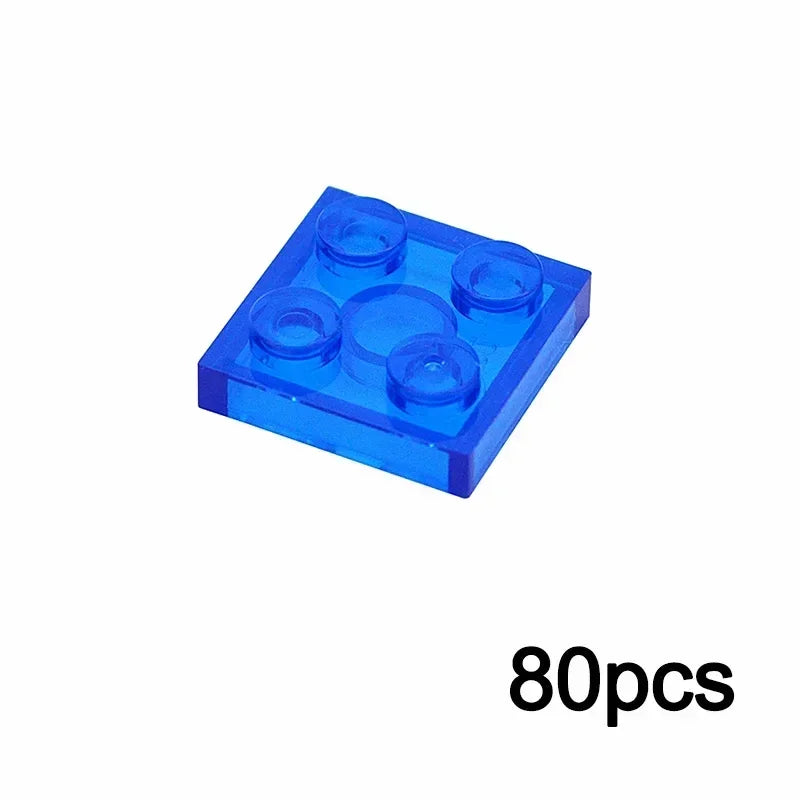 A 2x2 transparent blue brick from the MOC Transparent Bulk Brick Set, compatible with Lego, is shown on a white background. The text 80pcs appears in black at the bottom right—ideal for expanding your building block collection.