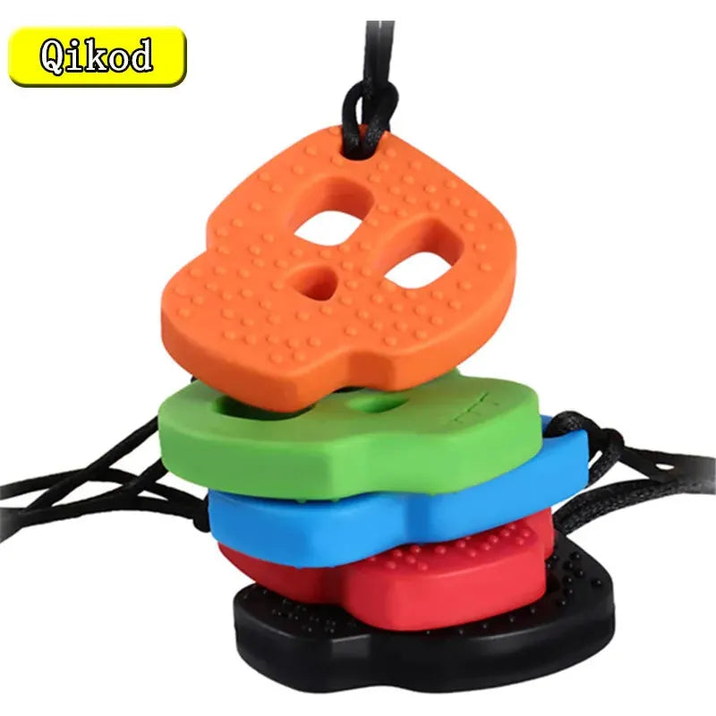 Vibrant silicone skull-shaped teething necklaces from Qikod feature orange, green, blue, red, and black designs with textured surfaces for teething relief. These sensory chewy toys dangle from black cords and are ideal for babies with Autism or ADHD.