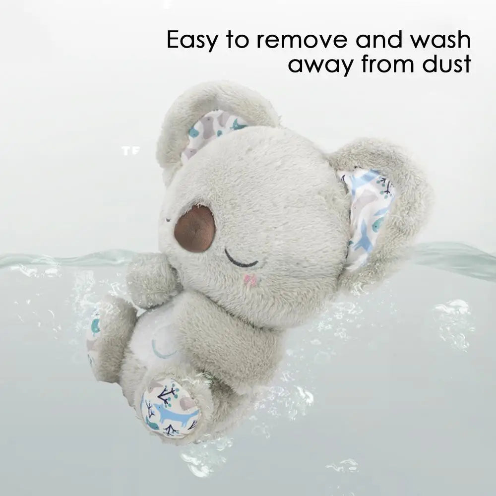 A Koala Night Light Plush Toy is gently washed, featuring embroidered eyes, a brown nose, and patterned fabric inside its ears. Text above reads, Easy to remove and wash away from dust. Ideal for bedtime cuddles with soothing melodies.