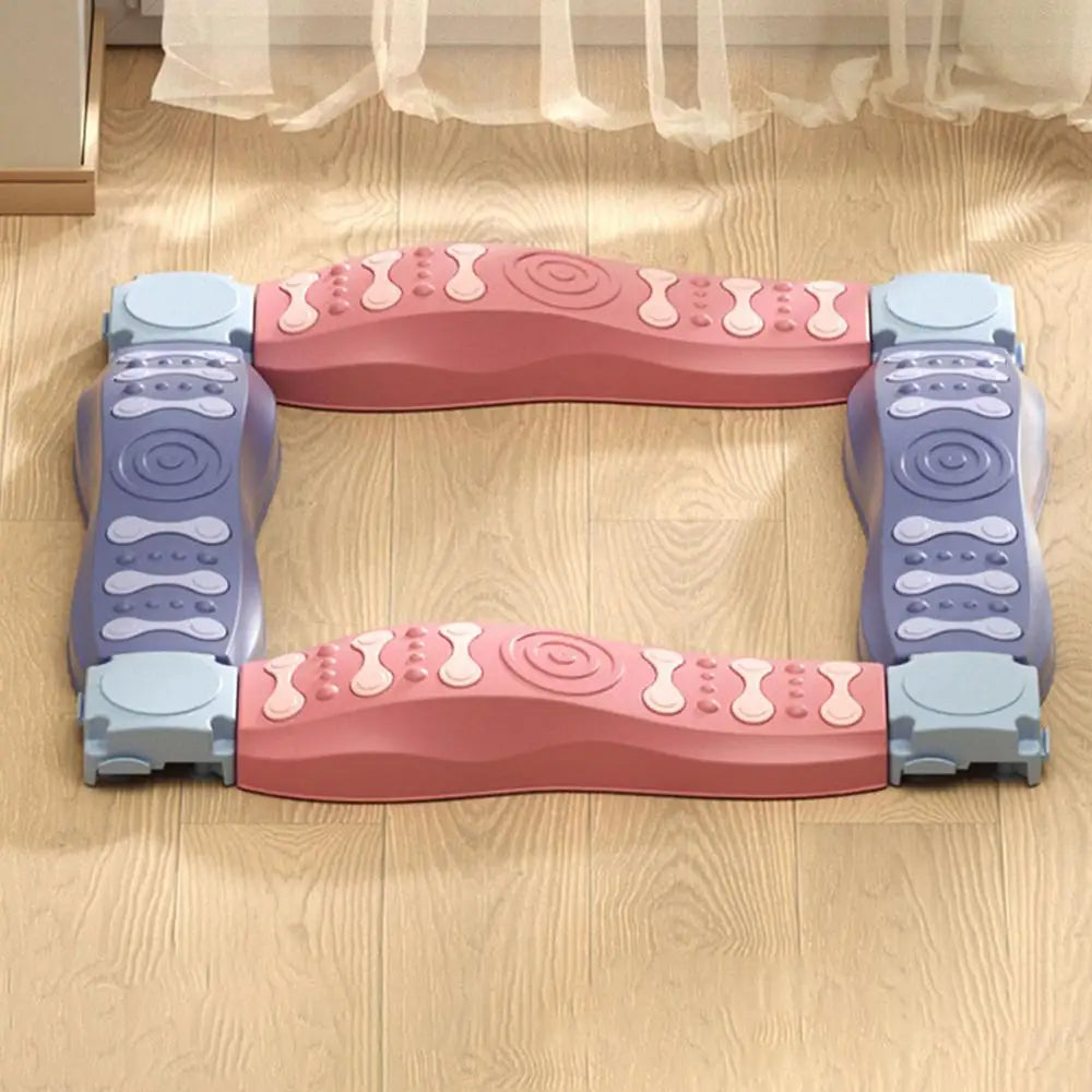 A Sensory Balance Beam Training Board for Kids in pink and purple lays flat on a wooden floor. Its a foldable, stackable toy designed to enhance coordination and stability with textured surfaces for foot massage, promoting motor skills.