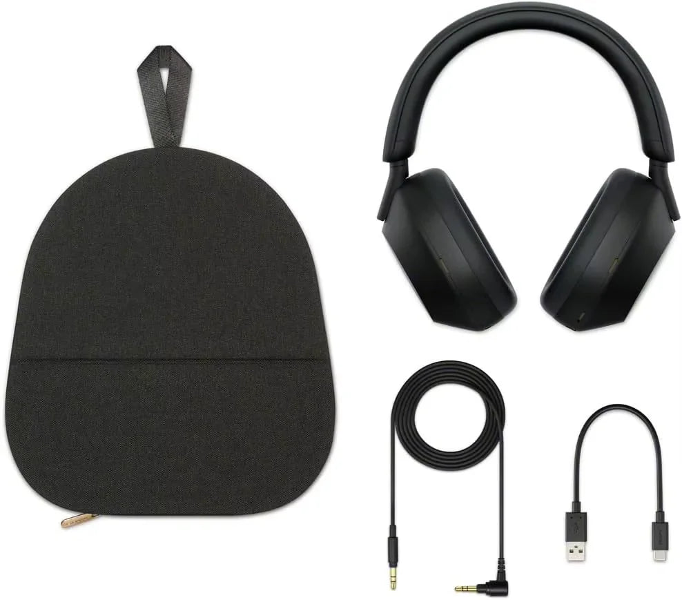 A black Sony WH-1000XM5 Wireless Noise Canceling Headphones set with Soft Fit Leather, 4 microphones, and 30-hour battery is shown on a white background with its carrying pouch, long audio cable, USB charging cable, and USB adapter.