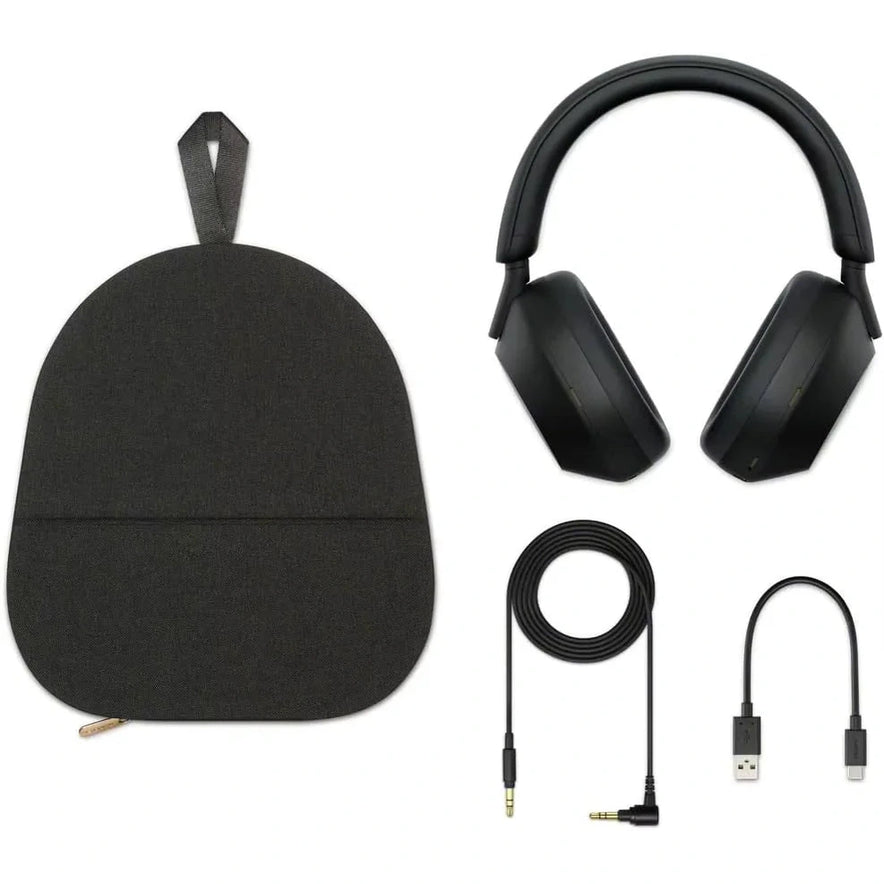 A black Sony WH-1000XM5 Wireless Noise Canceling Headphones set with Soft Fit Leather, 4 microphones, and 30-hour battery is shown on a white background with its carrying pouch, long audio cable, USB charging cable, and USB adapter.