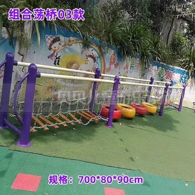 The Outdoor Steel Climbing Frame Swing for Childrens Sensory Integration Training features a balance bridge with rope steps, colorful tire seats, and purple posts. Set against a mural and greenery, text adorns the top and bottom of the image.