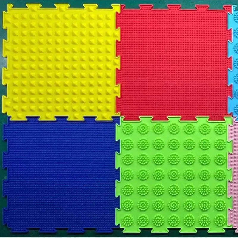 The Montessori Sensory Integration Training Balance Stones for Kids include four interlocking foam tiles: yellow with raised pyramids, red with small bumps, blue with fine ridges, and green adorned with circular bumps, creating ideal educational toys for engaging sensory play.