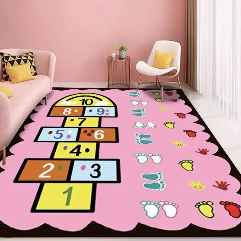 A playroom features the MINISO Cartoon Hopscotch Carpet (Color: 7) with numbers, footprints, and handprints, plus a pink sofa, yellow chair with pillow, small table, potted plants, and a non-slip rug for added safety.