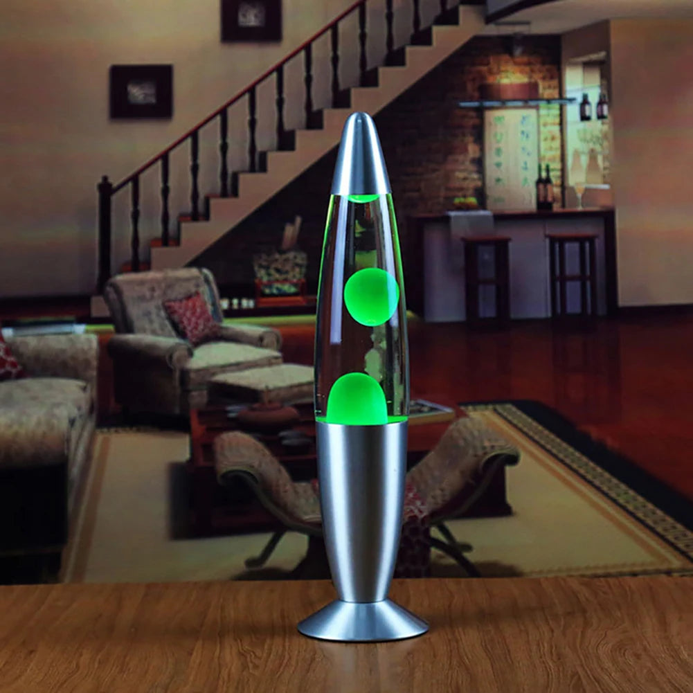The Luminous Volcano Lava Jellyfish LED Night Light with a silver base rests on a wooden table in the cozy living room, its 25W glow enhancing the relaxing ambiance amidst sofas, a staircase, and warm lighting.