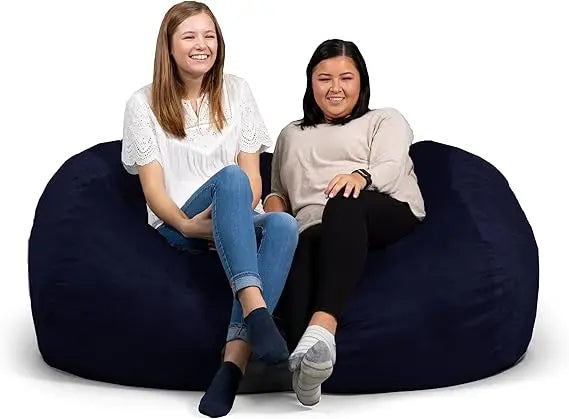 Two women sit comfortably on a Fuf XXL Foam Filled Bean Bag Chair, 6 feet, in Navy, smiling and relaxed against a plain white background.