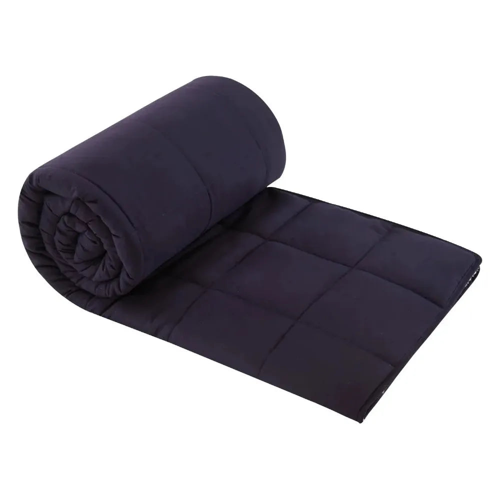 A partially unrolled navy blue Luxurious Microfiber Weighted Blanket showcases its quilted square pattern, appearing luxuriously soft and plush. Neatly coiled, it is set against a plain white background.