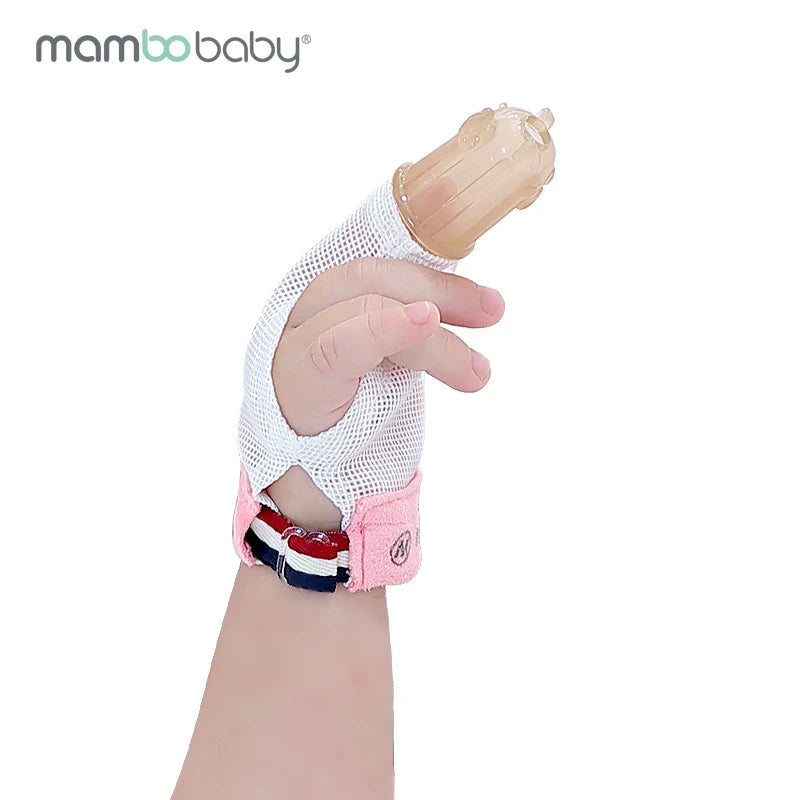 A Mambobaby glove with a silicone finger cot and thumb protector adorns an infants hand, featuring a pink and black strap to combat thumb-sucking. The distinctive branding ensures secure coverage.