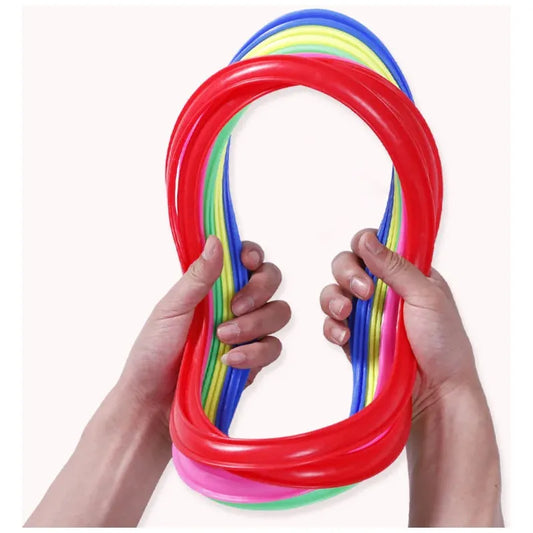 Two hands stretch and hold colorful silicone rings, ideal for outdoor play. The vibrant red, blue, yellow, green, and pink colors stand out against the white background. These rings can become a creative Childrens Jump Grid with educational benefits using the Family Fun Jumping Game for Kids toy.