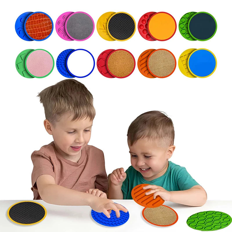 Two young children engage in developmental play with the Montessori Tactile Adventure Mat with Balance Stones, featuring colorful textured discs. As bubble designs and rough surfaces captivate them, their smiles reflect delight in this educational sensory experience.