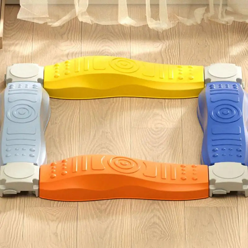 The Sensory Balance Beam Training Board for Kids, featuring stackable modular plastic pieces in blue, orange, yellow, and light blue with embossed textures, forms an open square on the wooden floor. The translucent curtains backdrop enhances the serene environment for motor skill development.