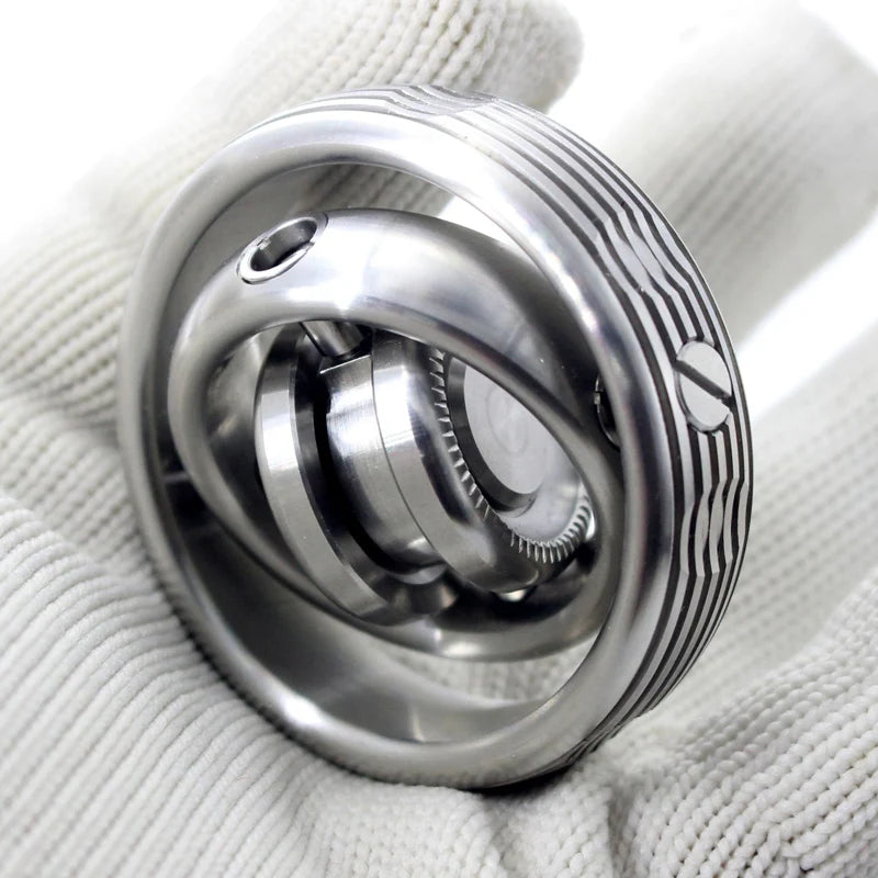 A person in a white glove holds the Stainless Steel Fidget EDC Gyroscope Spinner, showcasing its interlocking, rotating design and intricate engravings. This elegant stress relief toy for adults highlights exquisite craftsmanship.