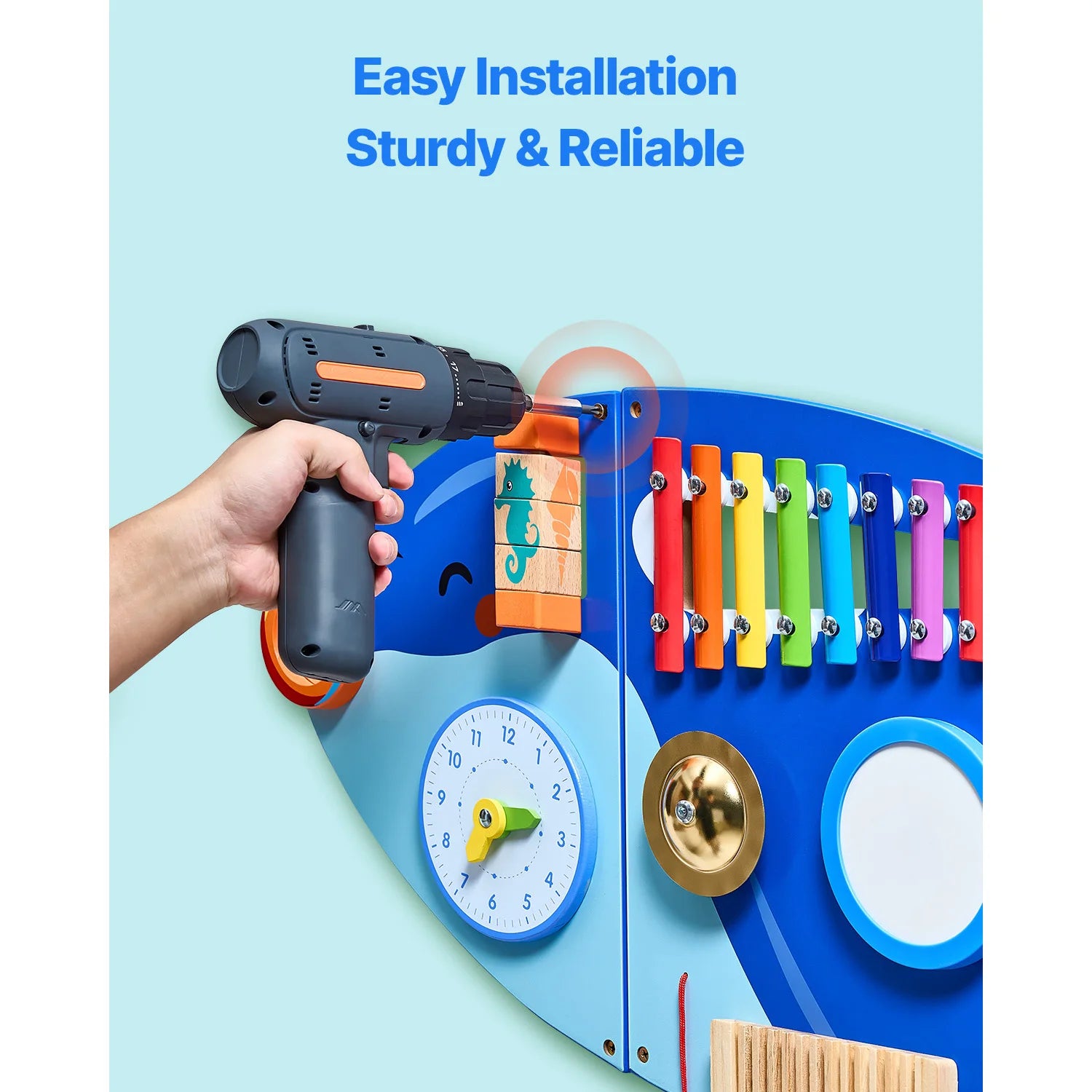 A hand uses a power drill to install the Vevor Orca Kids Wall Busy Board featuring 12 Montessori sensory activities, including a clock, xylophone, mirror, and more. Blue text above reads: Easy Installation Sturdy & Reliable.