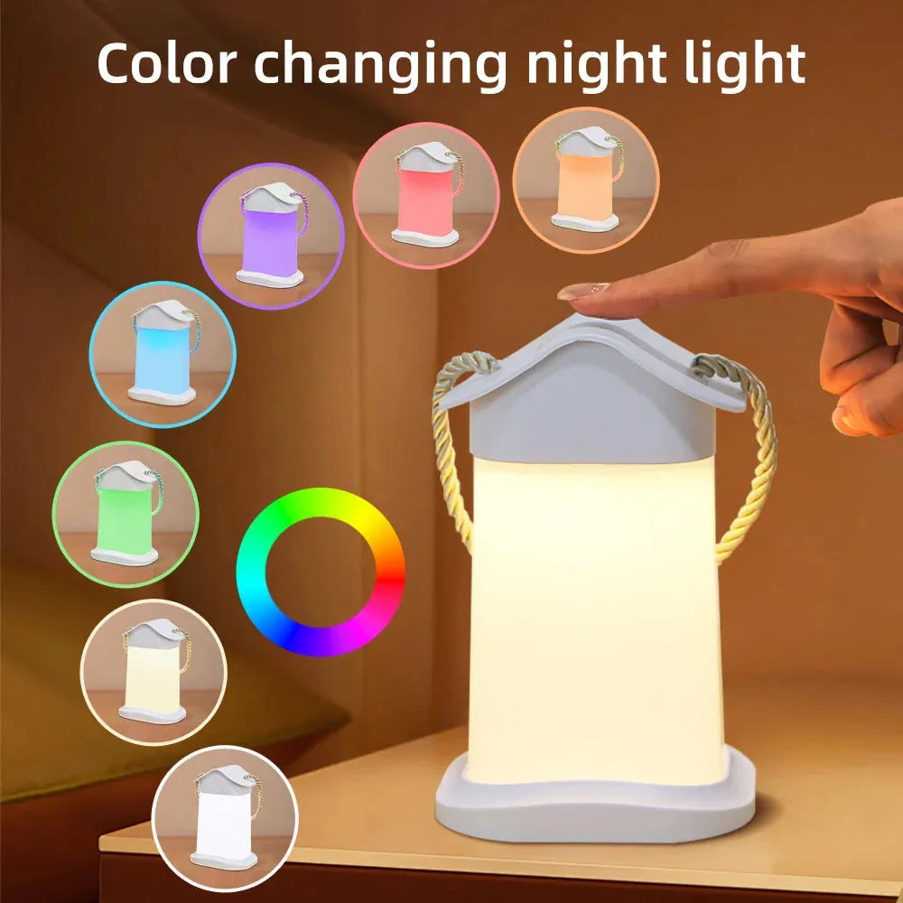 A Rechargeable Dimmable Touch LED Night Light sits on the table. Its USB-powered, has a braided handle, and comes in purple, pink, blue, green, orange, and white. A hand adjusts the bedside lamp via touch control. Nearby is a color wheel display.