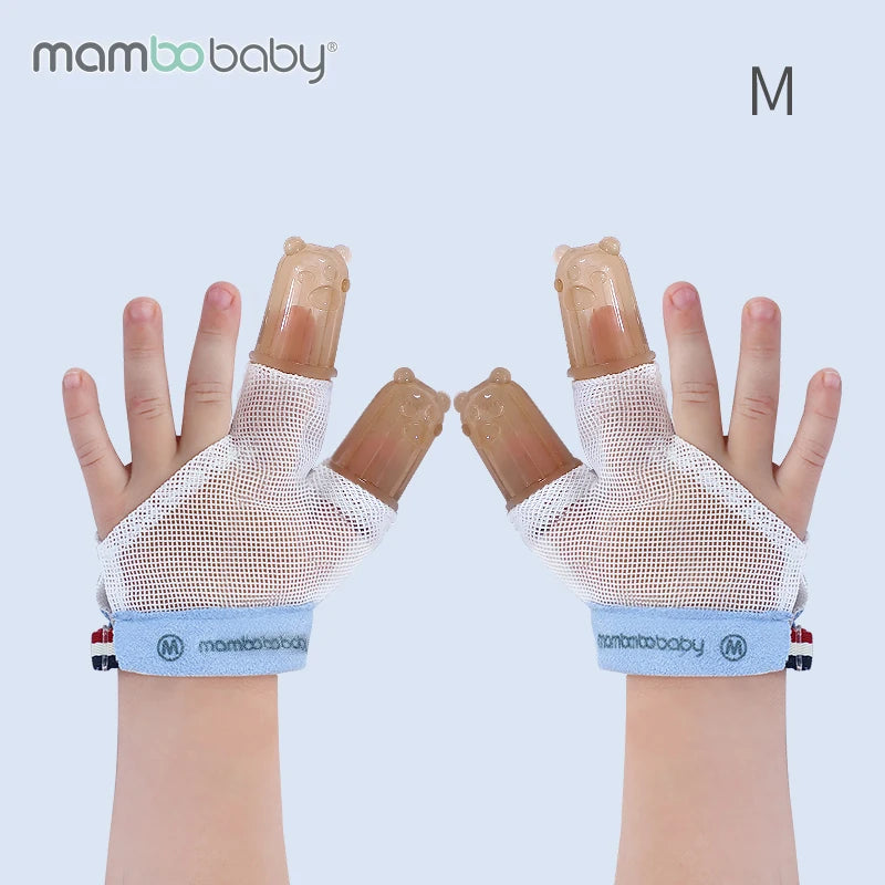 A childs hands wearing Mambobaby anti-nail biting gloves with bear-shaped brown silicone covers. These white gloves have blue wristbands labeled mambobaby, ideal for curbing thumb-sucking habits, and feature an M in the top right corner.